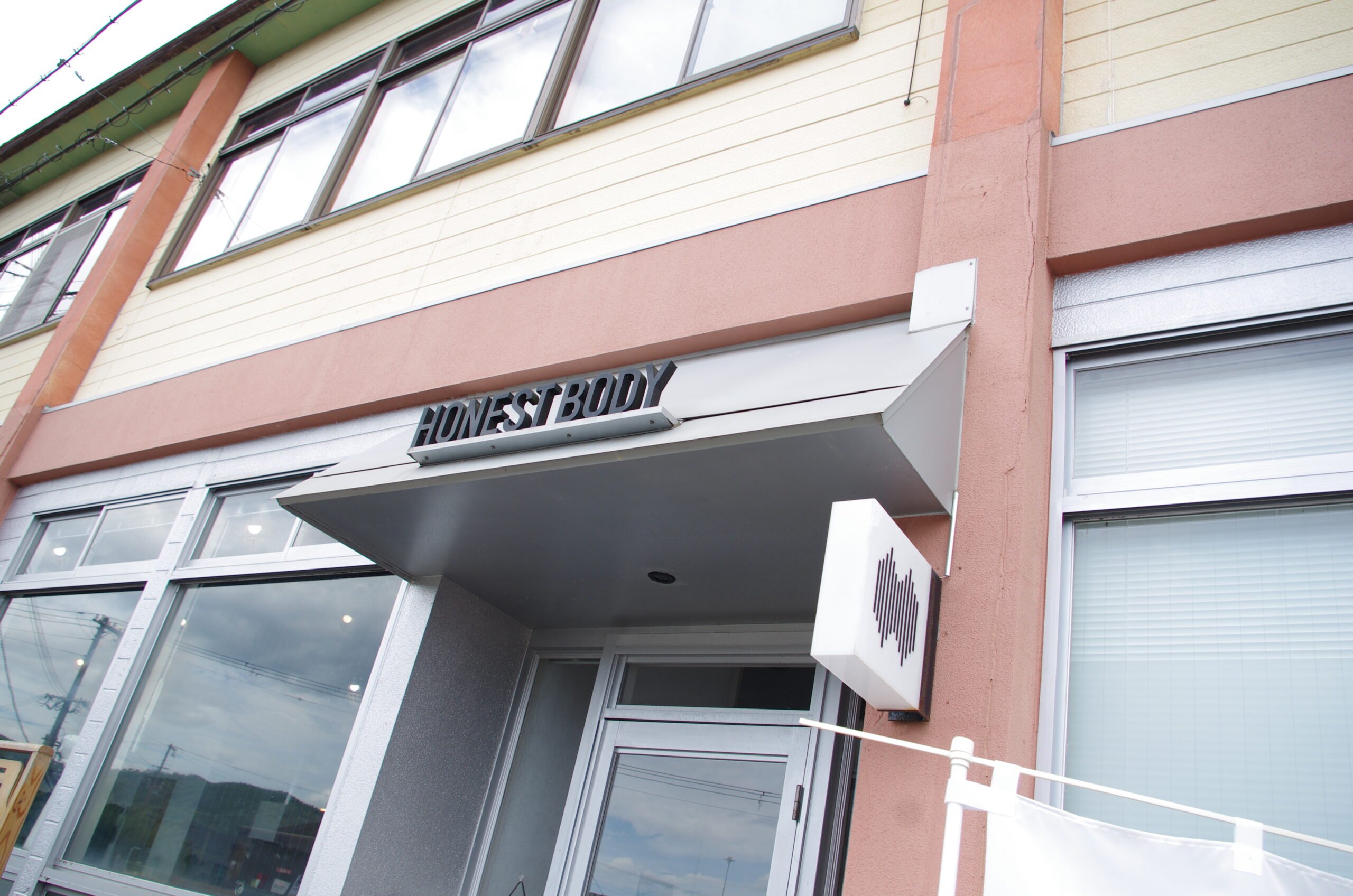 道路に面したHONEST BODYの入口と看板